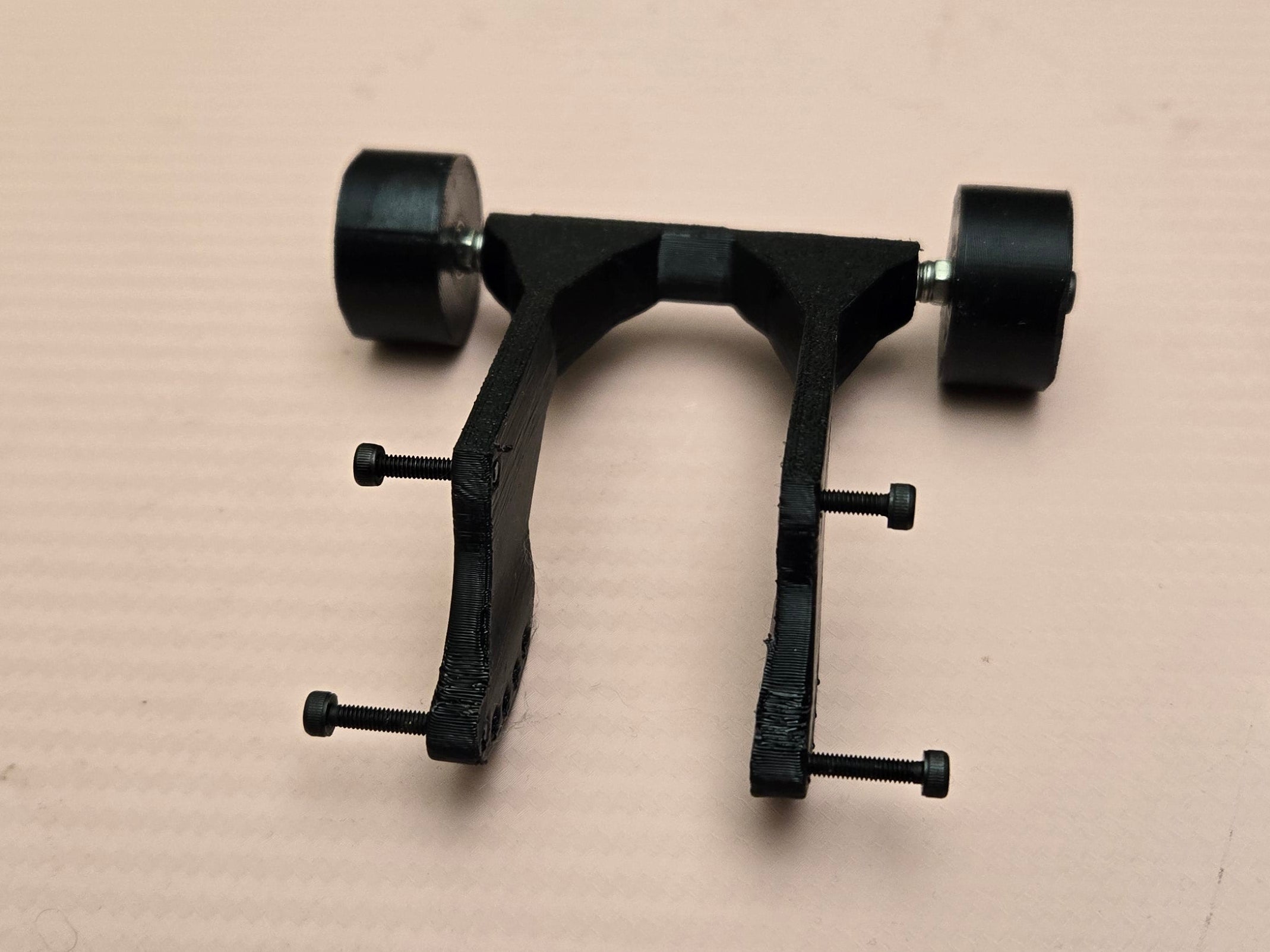 Black metal bracket on a cardboard surface